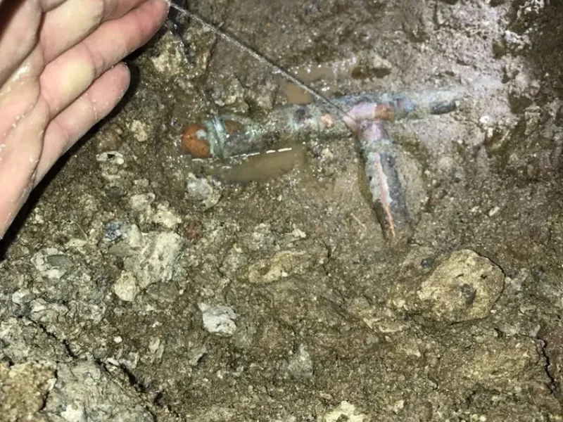 Exposed pipe beneath a slab prepared for repair